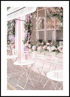 tables and chairs are lined up in front of a window with flowers on the windowsill