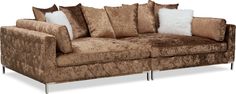 a brown couch with pillows on it and two white pillows sitting on top of it