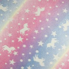 a rainbow colored background with white stars and unicorns