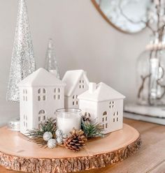 a candle is sitting on top of a tree stump in front of a white house