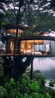 a tree house built into the side of a hill in the rain with trees surrounding it