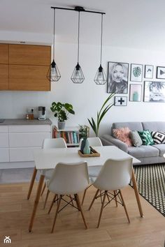 a living room filled with furniture next to a white table and chairs in front of a kitchen