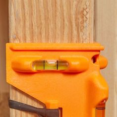 an orange door handle is attached to a wooden door with a screwdriver on it