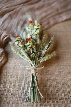 dried flowers are tied up on the bed