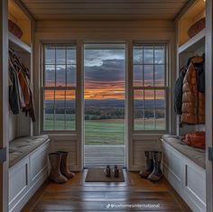 the sun is setting in an open room with lots of windows and boots on the floor