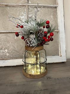 a vase filled with pine cones and berries