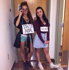 two young women standing next to each other in front of a door holding signs that say stay home