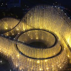 an aerial view of a large sculpture with lights on it's sides at night