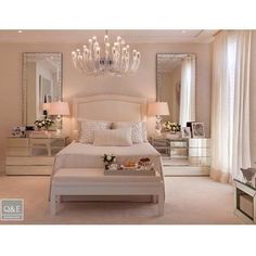 a white bed sitting in a bedroom next to a chandelier