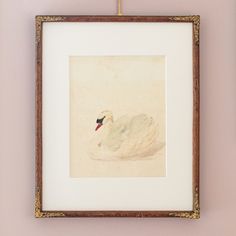 a white swan sitting on top of a bed under a painting hanging on the wall