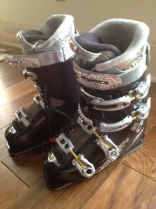 a pair of ski boots sitting on top of a wooden floor