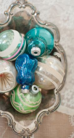 a glass bowl filled with ornaments on top of a table