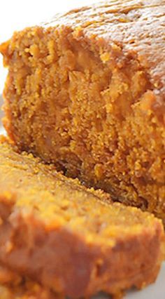 a loaf of pumpkin bread on a white plate with some slices cut out and ready to be eaten