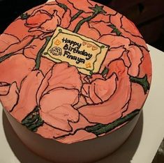 a birthday cake decorated with pink flowers on a table