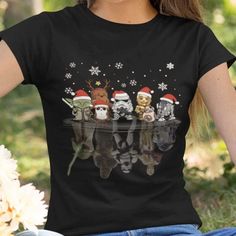 a woman wearing a black shirt with christmas animals on it's chest and santa hats