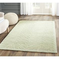 a white rug with wavy lines on the floor in front of a couch and chair