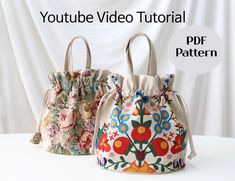 two flowered bags sitting on top of a white table with the words youtube video tutorial