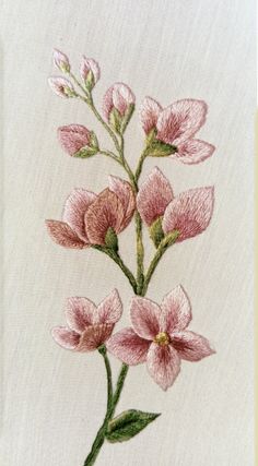 pink flowers on white linen with green stems and leaves in the center, embroidered onto fabric