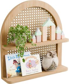 a wooden shelf with books and toys on it's sides, along with an owl figurine