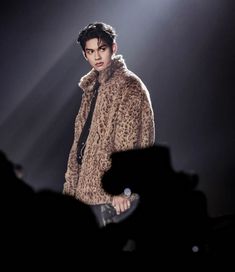 a man in a fur coat on stage