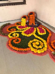 a large flower arrangement on the floor in front of a window