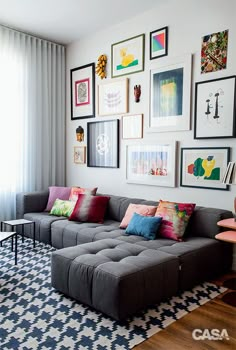 a living room filled with lots of furniture and pictures on the wall above it's couch