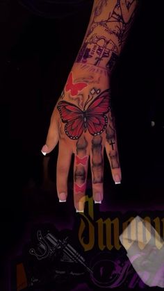 a woman's hand with tattoos on it and a butterfly tattooed on the palm