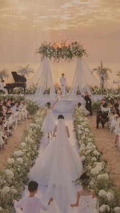 the bride and groom are walking down the aisle at their wedding ceremony in front of an audience