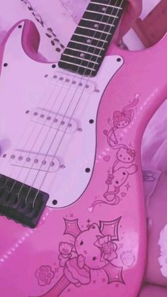 a pink guitar with hello kitty on it