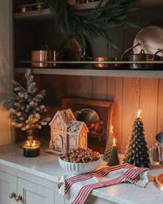 a kitchen counter topped with christmas decorations and candles