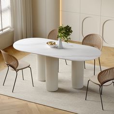 a white table with four chairs around it and a vase filled with flowers on top