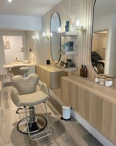 a hair salon with chairs, mirrors and lights on the wall next to each other