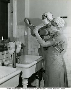 two women in scrubs are washing their hands