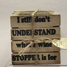 a stack of wooden blocks with words written on them, tied up and labeled i still don't understand who & wine stoppe is for