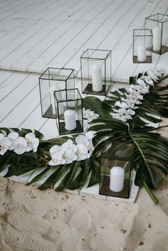 white flowers and candles are lined up on the ground