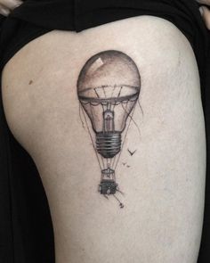 a woman's thigh with a light bulb tattoo on it