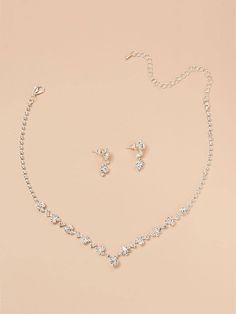 a necklace and earring set on a pink background