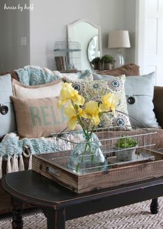 a living room filled with furniture and flowers on top of a coffee table in front of a couch