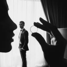 a man standing in front of a window next to a woman