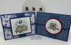 an open card with two owls on it and snowflakes in the background, sitting next to a white house