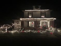 a house is decorated with christmas lights and wreaths