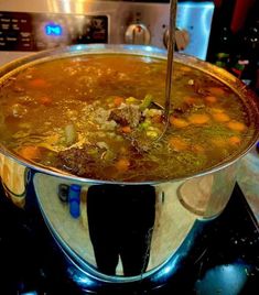 a pot filled with soup sitting on top of a stove