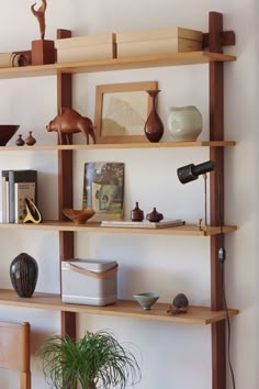 a wooden shelf with books, vases and other items on it's sides