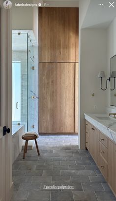 a large bathroom with wooden cabinets and tile flooring, along with a walk in shower