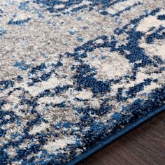 a blue and white rug on top of a wooden floor