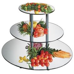 three tiered glass plate display with fruits and vegetables on each side, in front of a white background