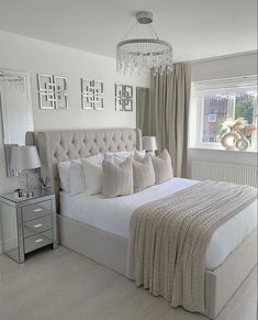 a bedroom with a large bed and chandelier