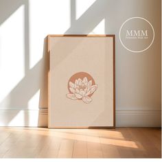 an empty frame on the floor in front of a white wall with a lotus flower