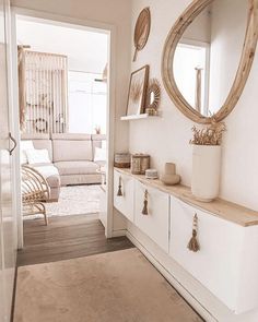 a living room with white furniture and a large mirror