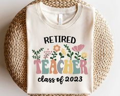 a t - shirt that says retired teacher class of 2013 on it next to a wicker basket